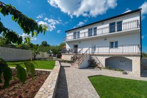 a large white building with a balcony at Villa The Rock in Unešić