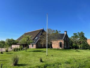 a house with a pole in the yard at B&B Eindeloos in Opeinde