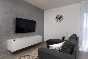 a living room with a couch and a tv on a wall at Villa The Rock in Unešić