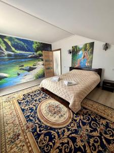 a bedroom with a bed and a painting on the wall at The Selo in Korostovat