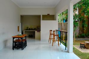 a room with a table and chairs and a kitchen at Ungasan Center Hostel in Jimbaran