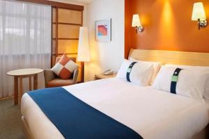 a hotel room with a large bed and a chair at Holiday Inn York by IHG in York