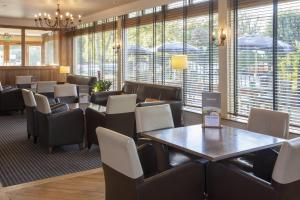 a waiting room with tables and chairs and windows at Holiday Inn York by IHG in York