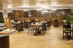 a dining room with tables and chairs and chandeliers at Holiday Inn York by IHG in York +83 photos