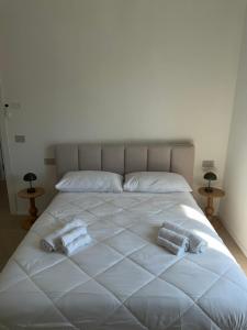 a large white bed with two towels on it at Lungomare 83 in Francavilla al Mare