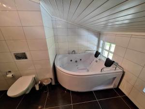 a white tub in a bathroom with a toilet at Aurlandsdalen in Aurland +26 photos