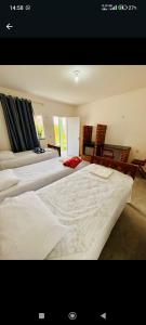 a large bedroom with two beds and chairs at Pousada Padre Pio CE in São Benedito