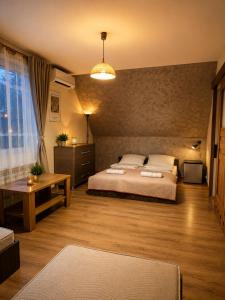 a bedroom with a large bed and a table at Brzegowy Relaks in Mszana Dolna