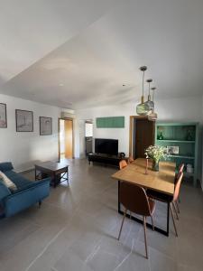 a living room with a table and a blue couch at CALIZA y LUZ in Arcos de la Frontera