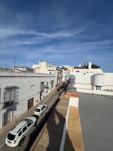 two cars parked on the side of a building at CALIZA y LUZ in Arcos de la Frontera
