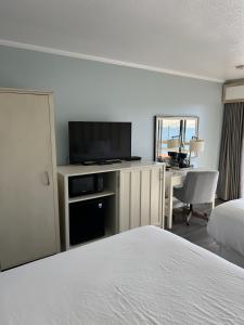 a hotel room with a bed and a flat screen tv at River House Inn, a Baymont by Wyndham in Florence