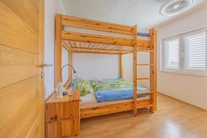 a bedroom with a bunk bed with a ladder at Apartments at Frapa in Rogoznica