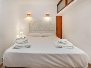 a bedroom with a large white bed with towels on it at Apartment Vermell-8 by Interhome in Platja d'Aro
