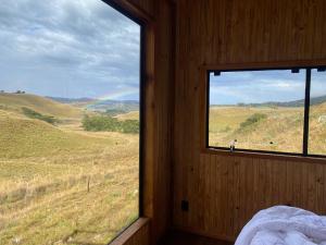 a bedroom with a window with a view of a field at Cloud Valley in Bom Jardim da Serra