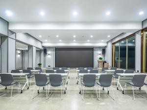 a conference room with tables and chairs and a chalkboard at Mercure Qingdao Downtown in Qingdao