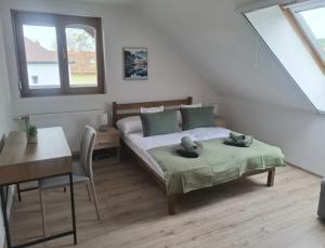 a bedroom with a bed and a table and a desk at Green Home Apartman in Nemesvámos
