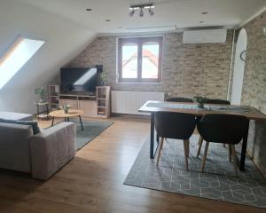 a living room with a table and a couch at Green Home Apartman in Nemesvámos