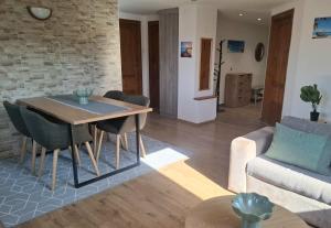 a living room with a table and chairs and a couch at Green Home Apartman in Nemesvámos