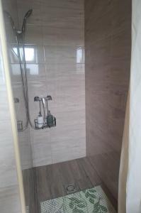 a shower with two faucets in a bathroom at Green Home Apartman in Nemesvámos +5 photos