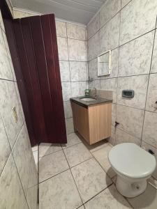 a bathroom with a toilet and a sink at Refúgio da Sombra House in Rondonópolis +24 photos