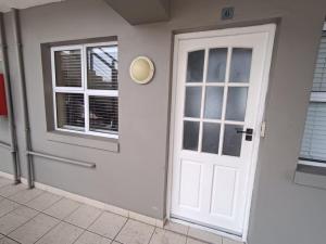 a white door and window on a building at 6 Vasco Mews in Mossel Bay