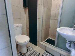 a bathroom with a toilet and a sink at 6 Vasco Mews in Mossel Bay +9 photos