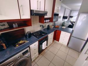 a small kitchen with a stove and a dishwasher at 6 Vasco Mews in Mossel Bay