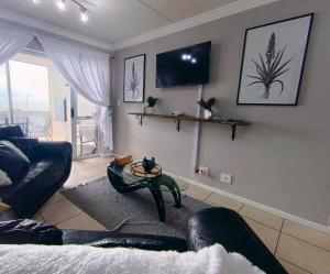 a living room with a couch and a table at 6 Vasco Mews in Mossel Bay
