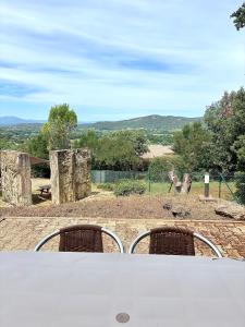 a giraffe standing in a field with two chairs at Maison proche vallon pont d arc in Salavas