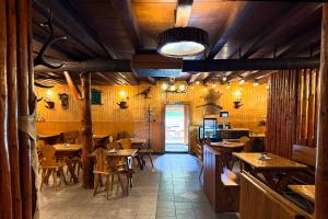 a restaurant with wooden tables and chairs in a room at Koliba Hoděšovice in Býšť +43 photos