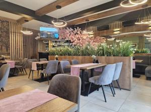 a restaurant with tables and chairs and flowers at Klimat Sadu Noclegi in Jaśkowice