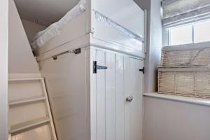 a white closet with a door and a window at 2 Bed in Croyde oc-smithc in Croyde +16 photos
