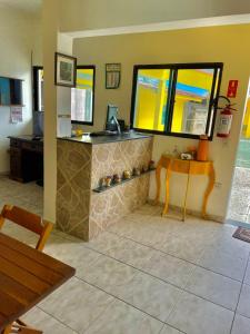 a restaurant with a counter with a table and a mirror at Pousada ENCANTOS de PERUÍBE in Peruíbe