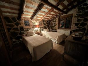 a bedroom with two beds and a stone wall at VUT La Greda in Leganiel +35 photos