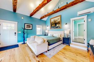 a bedroom with blue walls and a bed and a couch at The Lodge - Suite #3 in Waterbury