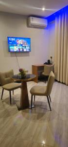 a waiting room with chairs and a table and a tv at Cornerstone Hotel Arusha in Arusha