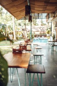 a group of tables and benches in a restaurant at Paddle Cult Surf & Yoga in Varkala