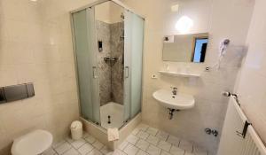 a bathroom with a shower and a toilet and a sink at Hotel & Restaurant Klosterschänke in Ruhla +13 photos