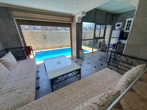 a room with a bed and a table and a pool at la sublime in Taghazout