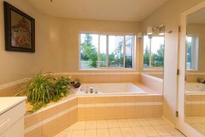 a large bathroom with a tub and a window at Mountain and Ocean Views Art Deco House in West Vancouver +36 photos