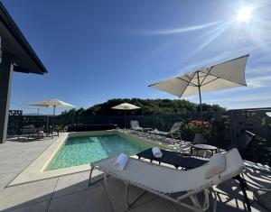 a swimming pool with lounge chairs and an umbrella at Northern Croatia Accessible Luxury Villa in Cestica