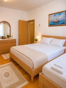 a bedroom with two beds and a mirror at Apartments Nuhi in Ulcinj