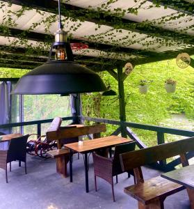 a patio with tables and chairs and a pendant light at Hotel Tys in Dilove