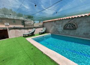 a swimming pool with two chairs next to a building at VUT La Greda in Leganiel
