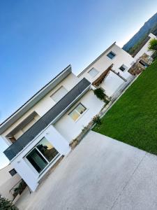 a large white house with a green lawn at Casa Pace - jardin - 2 chambres - Biguglia in Biguglia