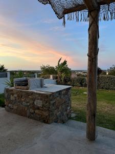 a stone barbecue grill with a stone wall at Casa Pace - jardin - 2 chambres - Biguglia in Biguglia