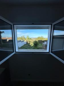 a window in a room with a view of a yard at Casa Pace - jardin - 2 chambres - Biguglia in Biguglia