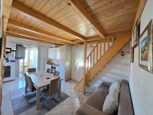 a living room and dining room with a table and a couch at Apartmani Kovač in Stara Novalja