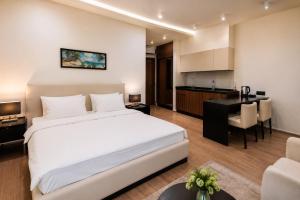 a bedroom with a large white bed and a kitchen at White Villas in Nardaran