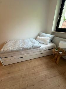 a white bed with pillows and a window in a room at Ferienwohnung am Park in Brilon +9 photos